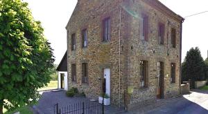 an old brick building with a white door at L'escaille in Brognon