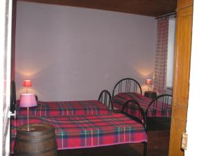 a bedroom with two beds and a table with a lamp at L'escaille in Brognon