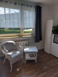 salon z krzesłem, stołem i oknem w obiekcie Pension am Sonnenhof w mieście Schmalkalden