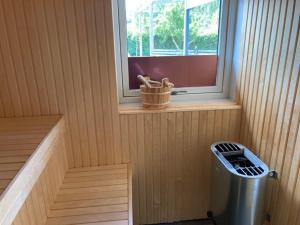 a sauna with a trash can and a window at Glamping i Döshult in Viken