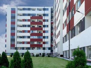 um grande edifício de apartamentos com um relvado em frente em Militari Comfort Studio em Roşu