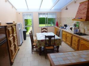 - une cuisine avec une table, une table et des chaises dans l'établissement Gite de vieille maison rouge, à Rocroi