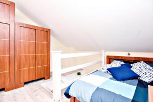 a bedroom with a bed and a wooden cabinet at Rent40 Sopot Łokietka 47D in Sopot