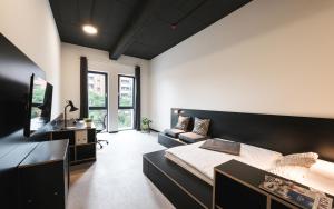 a bedroom with a bed and a couch in it at MoLiving - Design Hotel & Apartments Düsseldorf-Neuss in Neuss