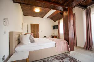 a bedroom with a large white bed with wooden ceilings at Vila Smaranda in Predeal