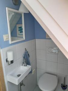 ein Bad mit einem Waschbecken und einem WC in der Unterkunft Giebelzimmer mit Weinbergblick in Stetten