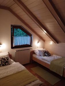 two beds in a room with a window at Apartmani Gruzdovo in Delnice