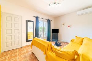 sala de estar con sofá amarillo y ventana en Agia Sana house Gardenos, en Vitalades