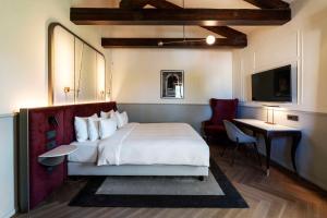 um quarto de hotel com uma cama, uma mesa e uma cadeira em Radisson Collection Hotel, Palazzo Nani Venice em Veneza