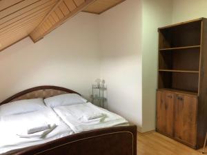 a bedroom with a bed and a book shelf at Penzion Obora in Tachov