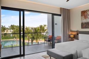 1 dormitorio con 1 cama y balcón con piscina en Angsana Ho Tram en Ho Tram