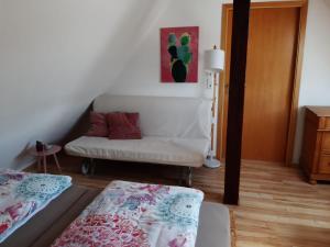 ein kleines Wohnzimmer mit einem Sofa in der Unterkunft Giebelzimmer mit Weinbergblick in Stetten