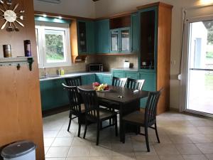 a kitchen with green cabinets and a table and chairs at Villa Aphrodite in Pastida