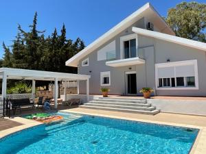 a villa with a swimming pool and a house at Villa Aphrodite in Pastida