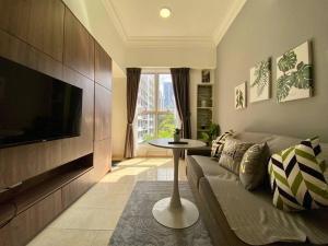 uma sala de estar com um sofá, uma televisão e uma mesa em Cosy 2 Bedder Near KLCC I 500mbps Wi-Fi I Smart TV with Netflix Function em Kuala Lumpur