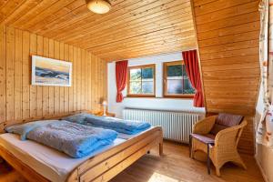 ein Schlafzimmer mit einem Bett und einem Stuhl in einem Zimmer in der Unterkunft Landhaus Graf in Kniebis