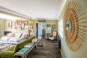 a living room with a green couch and a mirror at Bachelors Lodge in Sudbury