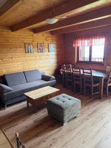 a living room with a couch and a table and chairs at Chaty Lipa in Levoča