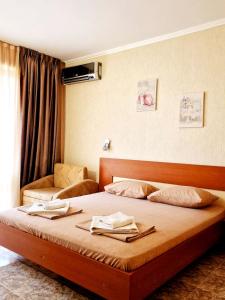 1 dormitorio con 1 cama con 2 toallas en Family Hotel Karel, en Nesebar