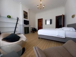 a bedroom with a bed and a couch and a chair at Villa Stella Maris in Ostend