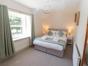 a small bedroom with a bed and a window at Rose Bank Cottage in Carlisle