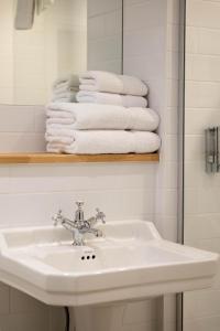 a bathroom with a sink and a mirror and towels at The Wishful Thinker in Kent