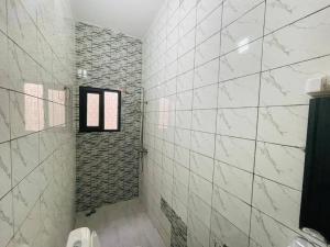 a bathroom with white tiled walls and a window at Appartement T 2 N 1: Résidence LES 11 PLURIELLES 