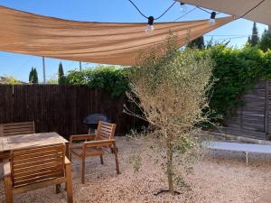 a patio with a table and chairs under a canopy at A 5mn à pied du port ! in Carqueiranne