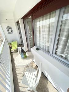 a balcony with a table and chairs and a window at Cosy hyper central typical home in Agadir