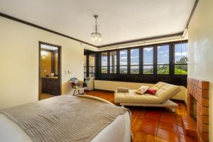 a bedroom with a bed and a couch and windows at Isatour - Ninho D' Águia in Águeda