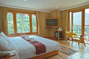 a bedroom with a large bed and a television at Cholay Khangzang in Thimphu