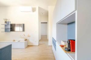 eine Küche mit weißen Wänden und Holzböden in der Unterkunft Appartamento Michelangelo in Prato