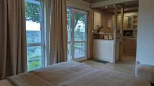 a bedroom with a bed and a large window at Rodynnyi Maietok Family Estate in Kamianets-Podilskyi