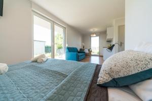 a bedroom with a large bed and a blue couch at Verde House in Karwia