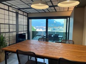 ein Esszimmer mit einem Tisch und Stühlen sowie einem großen Fenster in der Unterkunft Garden Inn - Riva del Garda in Riva del Garda