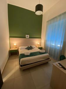 1 dormitorio con cama y pared verde en RUMA GUESTHOUSE, en Nápoles