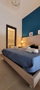 1 dormitorio con 1 cama grande y pared azul en RUMA GUESTHOUSE, en Nápoles
