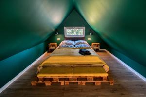 um quarto com uma cama grande numa sala verde em Domandi mountain holiday lodges em Przesieka