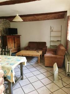een woonkamer met een bank en een tafel bij Les jonquilles in Rancennes