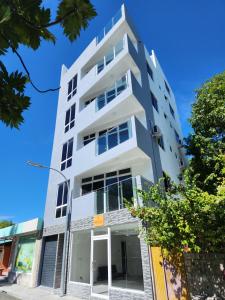 an apartment building with a white facade at EQUATOR RETREAT in Fuvahmulah
