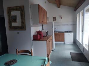 a small kitchen with a table and a refrigerator at Le Râteau Bavoir in Calvi