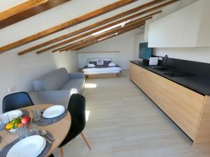 a kitchen and living room with a table and a couch at Dea Del Mar Apartments in Izola