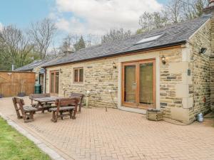 ein Steinhaus mit einem Picknicktisch und Bänken in der Unterkunft 4 Pheasant Lane in Sheffield