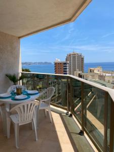 een balkon met een tafel en stoelen en uitzicht op de oceaan bij Esmeralda Suites in Calpe