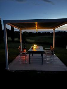 einen Tisch und Stühle unter einem Pavillon in der Nacht in der Unterkunft La casa terra dei sogni in Castiglione del Lago