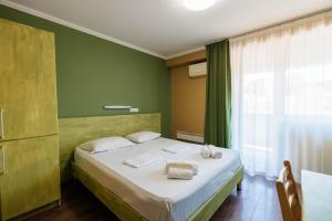 1 dormitorio con 1 cama con 2 toallas en Hotel Tbilisi Central by Mgzavrebi, en Tiflis