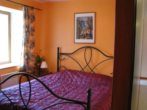 een bed met een paars dekbed in een slaapkamer bij Chez laure 