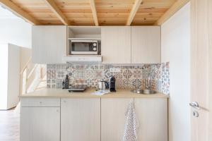 eine Küche mit weißen Schränken und einer Mikrowelle in der Unterkunft Mezzanine Apartments long-term in Budapest