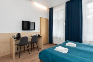 ein Hotelzimmer mit einem Bett, einem Tisch und Stühlen in der Unterkunft Matejki-Kawowy in Posen