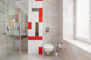łazienka z toaletą i czerwono-białą ścianą w obiekcie Matejki-Kawowy w Poznaniu